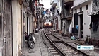 Train travels through narrow gap in-between houses in Vietnam